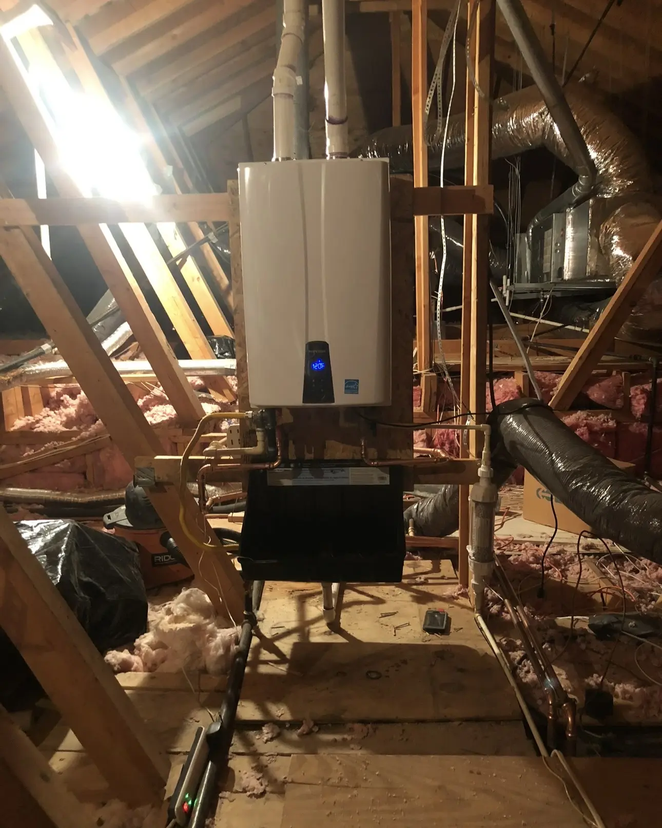 Tankless water heater with copper piping installed in an attic by MRC Plumbing Solutions